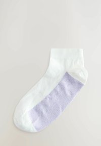 Witte enkelkous met een geribde boorden en een lavendelgekleurde textuurband over de voet. Materiaal lijkt zacht en rekbaar.