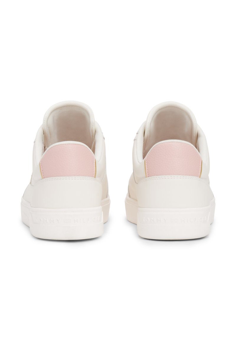 Baskets blanches avec une tige en cuir lisse, un accent en cuir rose au talon et une semelle en caoutchouc texturé arborant le logo de la marque.