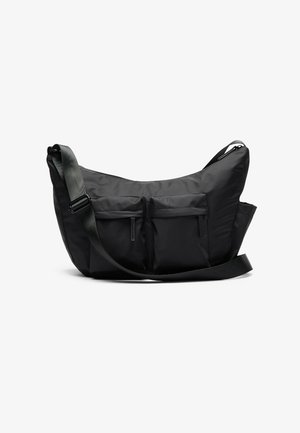 Schwarze Schultertasche mit geschwungener Form, ausgestattet mit zwei vorderen Reißverschlusstaschen und einem breiten, verstellbaren Trageriemen. Einfaches und funktionales Design.