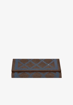 Bruin en blauw gevouwen stof met een geometrisch patroon van diamanten en cirkels en een klein rond metalen knopdetail.