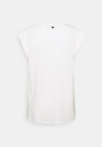 T-shirt en coton blanc avec manches courtes, encolure ronde et petit logo noir discret dans le haut du dos. Texture lisse.