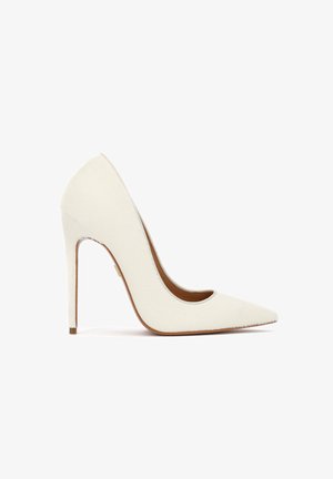 Hvid pump med spids tå og høj hæl med en slank stiletthæl og glat overflademateriale, vist i sideprofil på en hvid baggrund.