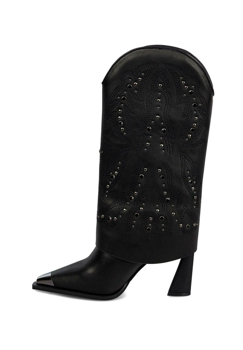 Botín negro hasta el tobillo con punta afilada y punta metálica. Presenta un corte decorativo con patrones perforados y tachuelas plateadas. Tacón ancho.