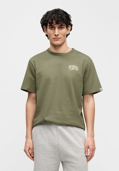 Πράσινο ελιάς κοντομάνικο μπλουζάκι με στρογγυλή λαιμόκοψη, με λευκό λογότυπο στο αριστερό στήθος και ετικέτα στο τελείωμα. Υλικό από απαλό βαμβάκι.