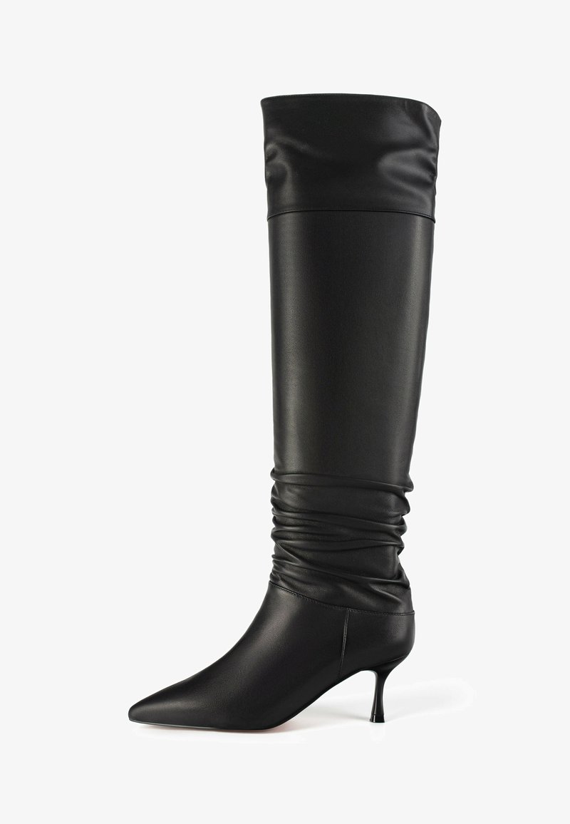 Crne kožne čizme do koljena s ležernim dizajnom, šiljastim vrhom i tankim potplatom. Glatka tekstura s elegantnim, minimalističkim profilom.