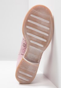 Semelle d'une chaussure rose perforée avec des motifs antidérapants, marque "TEN POINTS" et taille 37 embossée sur la semelle inférieure en caoutchouc.