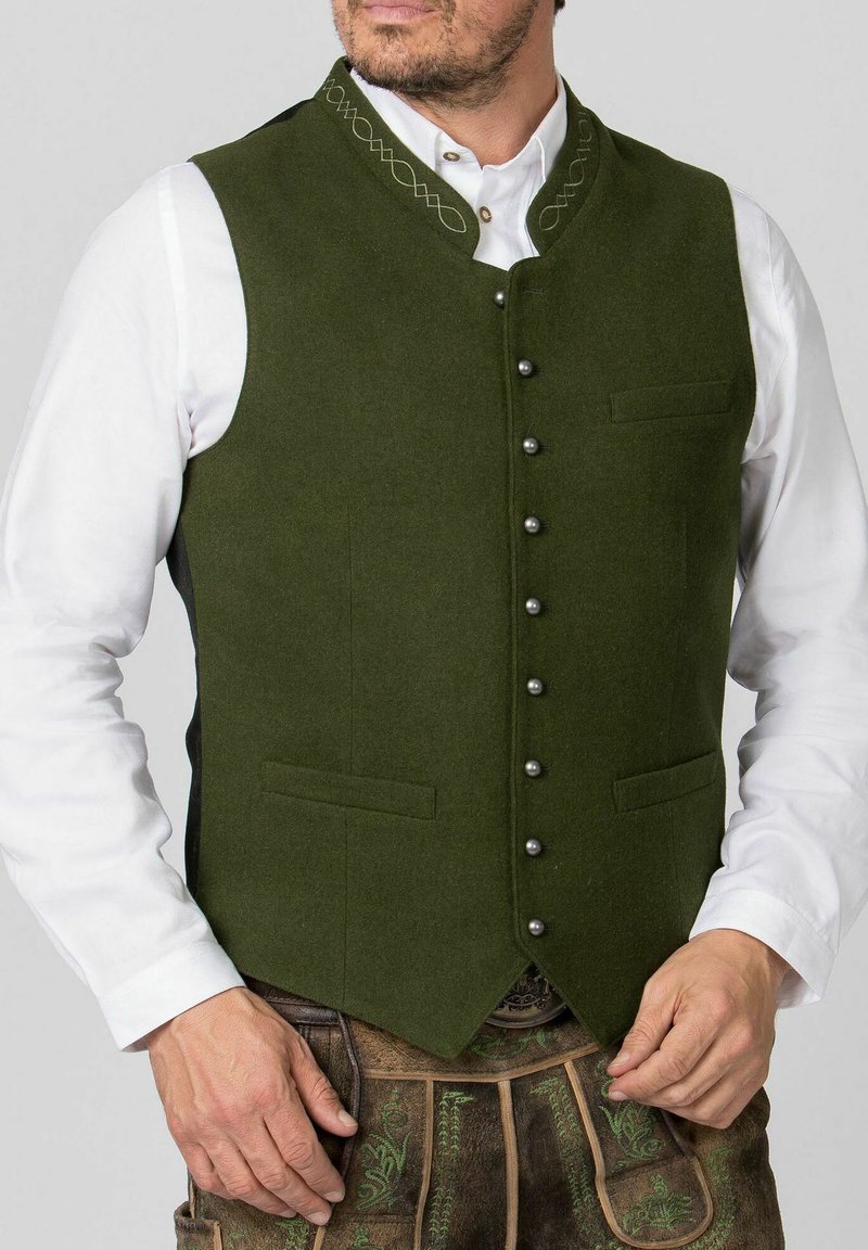 Grüner Wollweste mit hohem Kragen, silbernen Knöpfen, zwei vorderen Taschen und kunstvollen Stickereien am Ausschnitt.