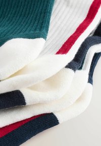 Calze in cotone a coste impilate, caratterizzate dai colori turchese, bianco, rosso e blu navy, con strisce contrastanti sui bordi superiori e inferiori.