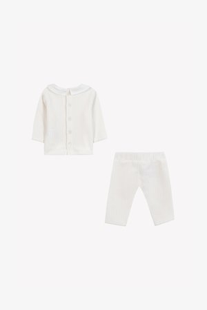 Witte geribbelde baby-outfit met een coltrui met lange mouwen, knoopsluiting en bijpassende elastische broek. Zachte textuur.