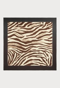 Tapis à motifs zèbre marron et crème avec une surface texturée, bordé d'un cadre noir solide. Présente des lignes ondulées et organiques dans tout le design.