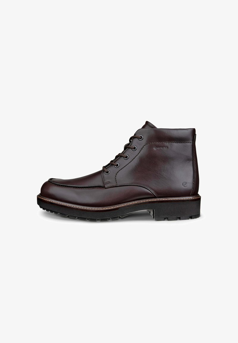 Bottines en cuir marron foncé. Les caractéristiques comprennent un design à lacets, un bout rond, des panneaux latéraux texturés et une semelle robuste pour une meilleure adhérence.