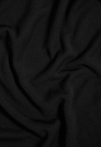 Czarna tkanina o miękkiej, gładkiej teksturze, z delikatnymi fałdami i zmarszczkami, podkreślająca jej lekką i elastyczną naturę.