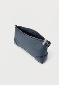 Granatowa skórzana sakiewka o teksturowanej powierzchni i zamknięciu na zamek błyskawiczny. Posiada płaski kształt i wzmocnione narożniki u podstawy zapewniające stabilność. Detale w srebrnym kolorze.