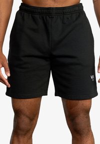 Black cotton shorts featuring an elastic waistband, side pockets, and a logo accent on the lower left leg. Smooth texture and classic fit.