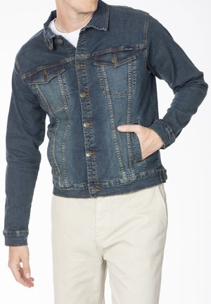 Veste en denim bleu foncé avec une fermeture à boutons, un col pointu, deux poches poitrine et des poches latérales. Détails usés le long des coutures.