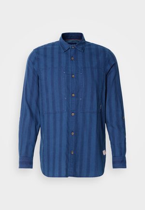 Camisa de manga larga a rayas azules, confeccionada en tela suave, con un cierre de botones en la parte delantera, dos bolsillos en el pecho y un cuello clásico.