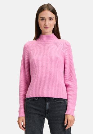 Rosa gerippter Pullover mit hohem Kragen, langen Ärmeln und tailliertem Schnitt. Hergestellt aus weichem, strukturiertem Material, das gut zu dunklen Jeans passt.