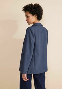 Blazer blu scuro in un tessuto strutturato, design a un petto, con revers a notched e polsini a tre bottoni. Vista posteriore, tasche visibili.