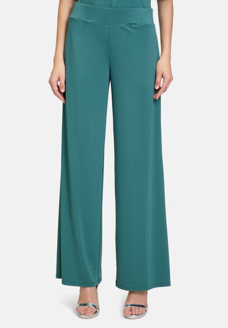 Teal wide-leg pants made of smooth fabric with a high waistband, featuring full-length legs and a clean, minimalist design. Silver heels included.