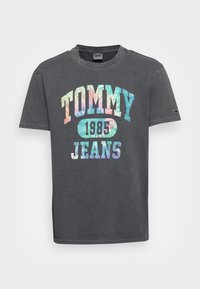 Grå bomullströja med en färgglad "TOMMY JEANS 1985" grafik i pastellfärger, rund halsringning och korta ärmar.