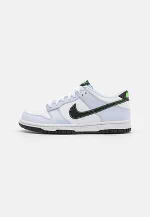 Nike Dunk Low sneakers med en overdel i hvid læder, sort Swoosh-logo, grønne søm detaljer og en struktureret gummisål.