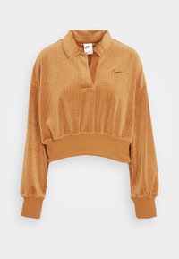 Oranger Velour-Crop-Top mit einer kragenförmigen Ausschnitt, gerippten Bündchen und einem dezenten Nike-Logo auf der Brust; strukturierter karierten Muster.