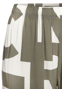 Elastic waistpants made of lightweight fabric feature a geometric pattern in olive green and white, with visible stitching and soft texture.