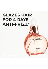 Kérastase Glaze Drops en un frasco redondo de vidrio rosa con cuentagotas. Textura suave, acabado brillante. El texto muestra detalles de uso de manera destacada.