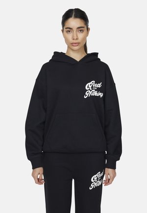 Ensemble de hoodie noir et de pantalons de survêtement, comprenant une poche frontale, un texte blanc "Good for Nothing", une coupe décontractée et une texture douce.