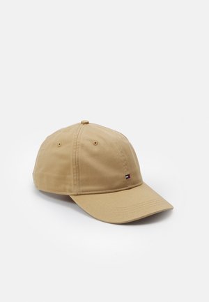 Beige baseballpet met een klein rechthoekig logo met rode, witte en blauwe strepen op het voorpaneel, afgebeeld op een effen witte achtergrond.