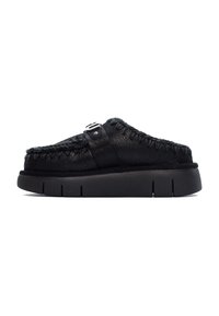 Scarpe nere slip-on con tomaia in pelle testurizzata, dettagli cuciti e suola in gomma con scanalature distinte. Accentato con una fibbia sulla cinghia.