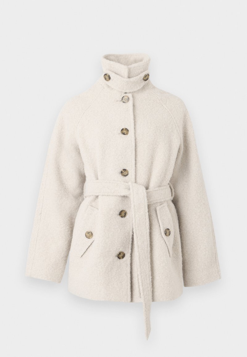 Cappotto in misto lana color crema con colletto alto, chiusura a bottoni frontale e cintura in vita. Presenta tasche laterali e bottoni decorativi marroni.