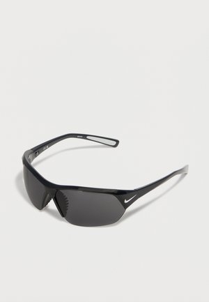 Mustad ümberkeeratavad spordipäikeseprillid tumedate läätsedega ja väikese valge Nike logoga külgvarrel.