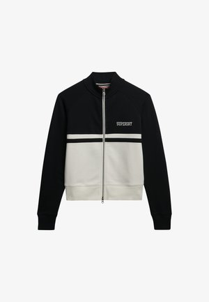 Sort og cremefarvet lynlåsfri jakke med høj krave, med "SUPERDRY"-logo på brystet og kontrasterende vandrette striber. Blødt stof.