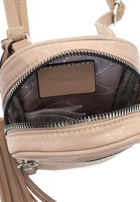 Kulatá hnědá crossbody taška se zipovým uzávěrem, uvnitř s vzorem a logem. Vyrobena z hladkého materiálu s jemným leskem.