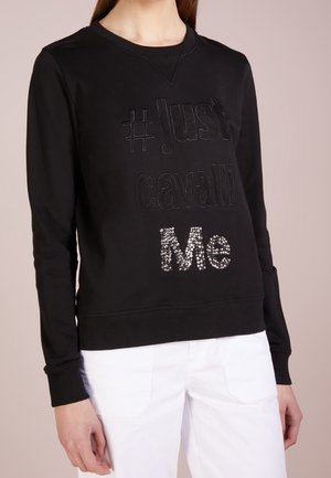 Sudadera negra con cuello redondo, que presenta un texto en relieve "#Just cavalli" y "Me" en strass en la parte delantera. Puños y dobladillo acanalados.