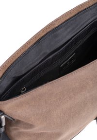 Borsa in tessuto marrone con fodera interna nera, che mostra una tasca interna con zip e un'etichetta parzialmente visibile all'interno del compartimento principale.