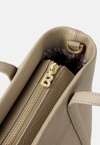Borsa a mano in pelle beige con superficie textured, chiusura con zip dorata e hardware metallico. L'interno presenta una fodera con motivo.