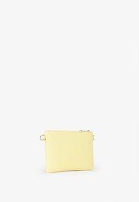 Borsa a tracolla rettangolare gialla con texture, dotata di chiusura con zip e un anello laterale per attacco. La superficie presenta un motivo a diamante.