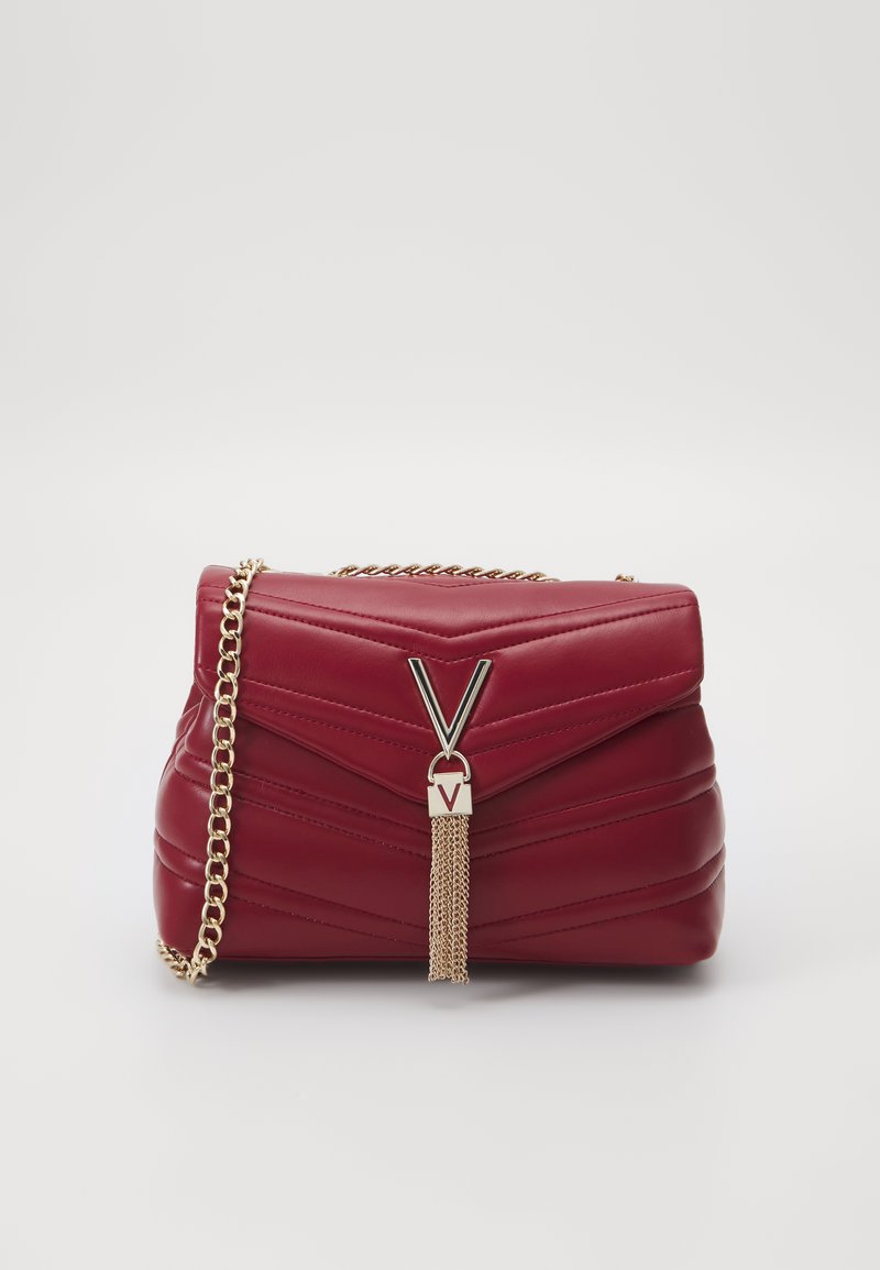 Rød kviltet lærveske med kjedestrop, med en metallisk V-formet detaljer og fransedetalj. Kompakt rektangulært design.