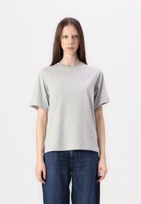 Grå t-skjorte med korte ermer laget av myk bomullsblanding med rund utringning og avslappet passform, sammen med mørkeblå vide jeans.