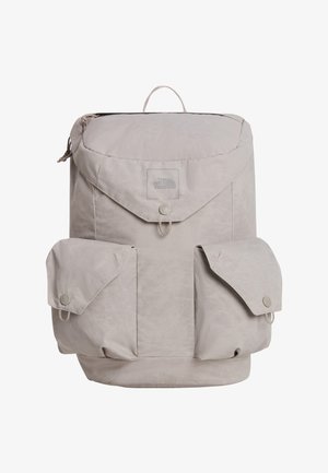 Jasnoszary plecak North Face z górną klapą, dwoma przednimi kieszeniami na guziki i małą pętlą do przenoszenia na górze.