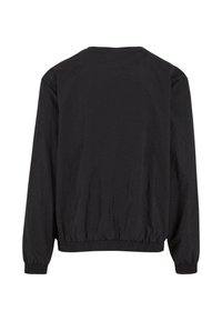 Veste noire à manches longues et col rond avec taille et poignets froncés, fabriquée en tissu léger, présentant une texture lisse et un design minimaliste.