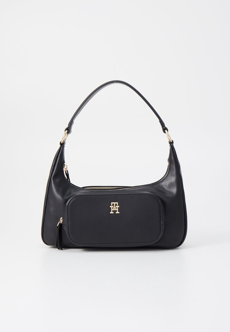 Sac à bandoulière en cuir noir avec poche zippée à l'avant et logo "TH" doré, bandoulière simple incurvée, et fermeture éclair supérieure.