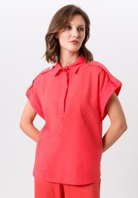 Koraal kleurig overhemd met korte mouwen en een button-down kraag, voorzien van schouderknopen en een soepele, lichte stof.