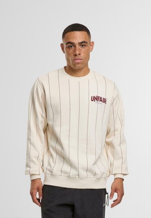 Helles beige Sweatshirt mit vertikalen burgunderfarbenen Streifen, gerippten Bündchen und Saum. Auf der Vorderseite befindet sich das "UNFAIR" Logo in Burgunderrot. Material aus Baumwollmischung.