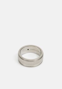 Sølvmetalring med et struktureret diagonalt mønster langs bæltet. Indersiden har påtrykningen "FOSSIL STEEL 10." Glat overflade, lavprofil design.