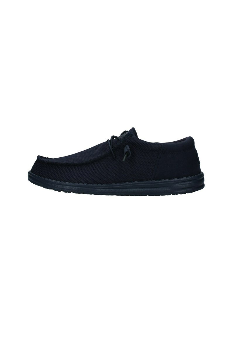 Zapatos negros sin cordones con un upper de tejido texturizado, punta redonda y suela de goma. Presentan un acento de cordón en el lateral para ajuste.