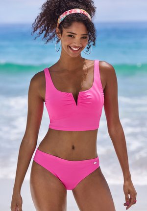 Pink ribbed bikini set featuring a cropped top with a V-neck and matching low-rise bottoms, both made from a textured swim fabric.