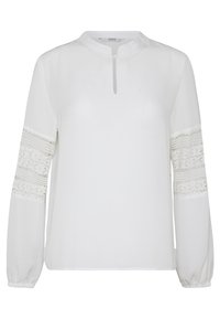 Blouse blanche à manches longues avec encolure ronde, fermeture à bouton en forme de trou de serrure et panneaux en dentelle florale sur les bras supérieurs.